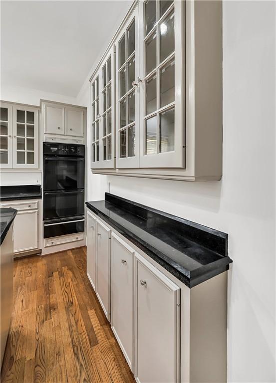 kitchen featuring double oven, gray cabinets, and dark hardwood / wood-style floors