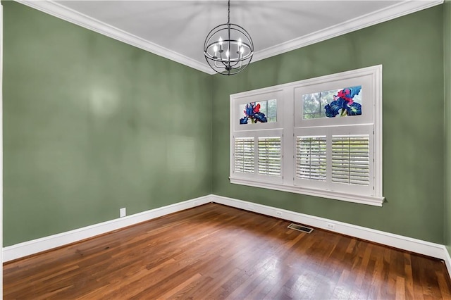 empty room with wood-type flooring, ornamental molding, and a chandelier