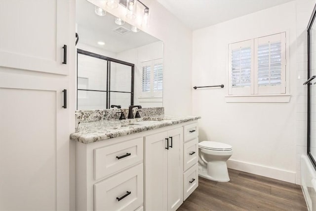 full bathroom with toilet, vanity, plenty of natural light, and hardwood / wood-style flooring