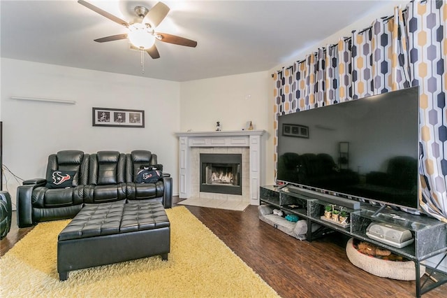 living room featuring a fireplace, wood finished floors, and a ceiling fan