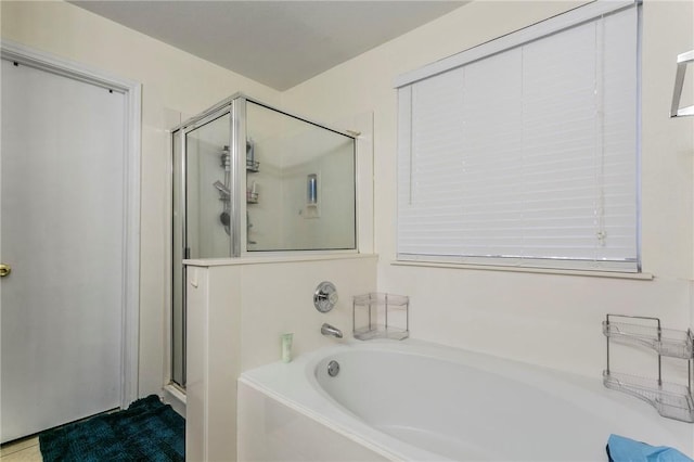 bathroom featuring a bath and a shower stall