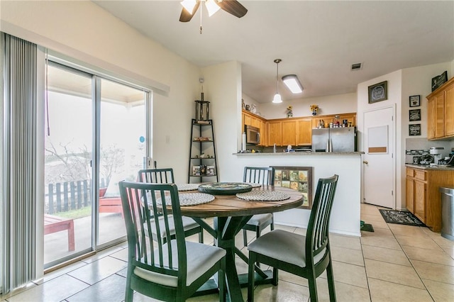 dining room with light tile patterned floors, a ceiling fan, and visible vents