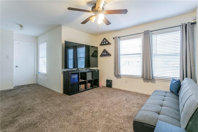 carpeted living area featuring a healthy amount of sunlight and a ceiling fan