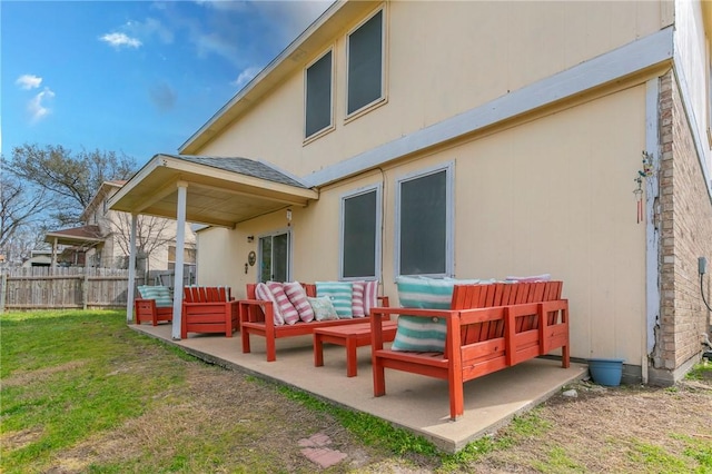 back of property with a patio area, an outdoor hangout area, a yard, and fence