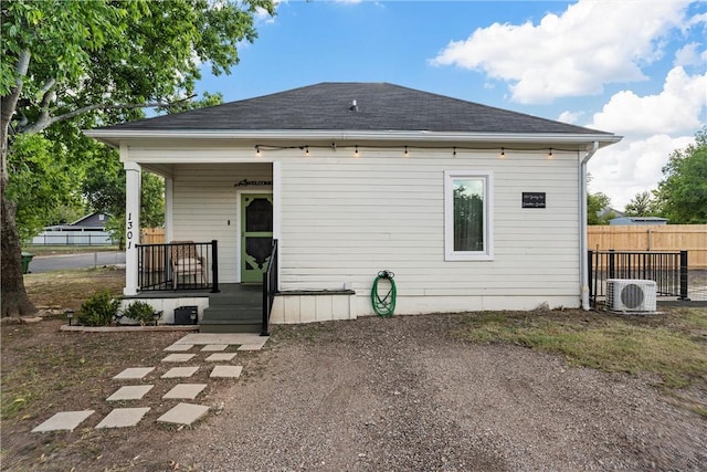 back of house with ac unit and a porch