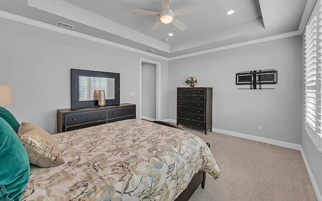 carpeted bedroom featuring ceiling fan, ornamental molding, and a tray ceiling