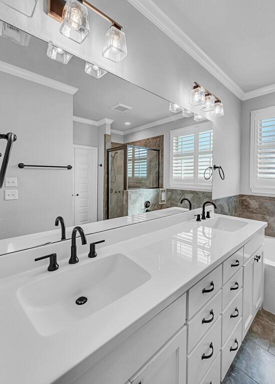 bathroom with vanity, crown molding, and separate shower and tub