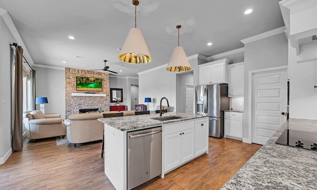 kitchen featuring white cabinetry, hanging light fixtures, light stone counters, and stainless steel appliances