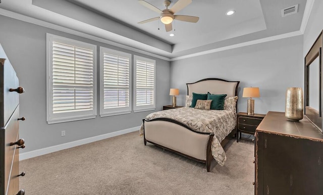 bedroom with ornamental molding, light colored carpet, and a raised ceiling