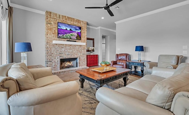 living room featuring a brick fireplace, hardwood / wood-style flooring, ornamental molding, and ceiling fan