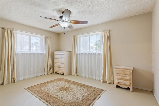 bedroom featuring multiple windows, a textured ceiling, and ceiling fan