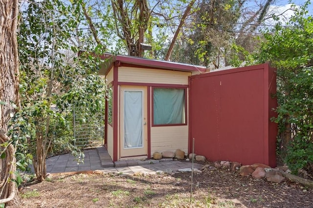 view of outbuilding featuring an outdoor structure and fence