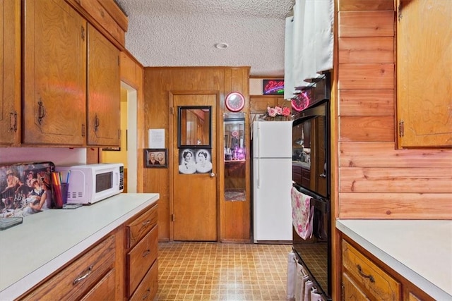 kitchen featuring white appliances, brown cabinetry, and light countertops