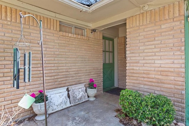 doorway to property with brick siding