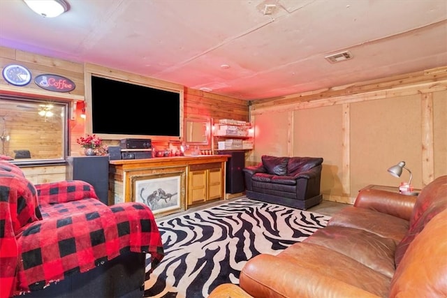 living area with visible vents and wooden walls