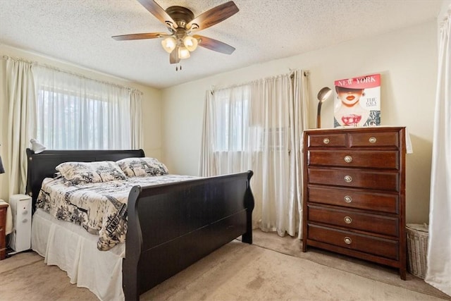 bedroom featuring light carpet, a textured ceiling, and ceiling fan