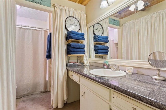 full bath featuring vanity and a textured ceiling