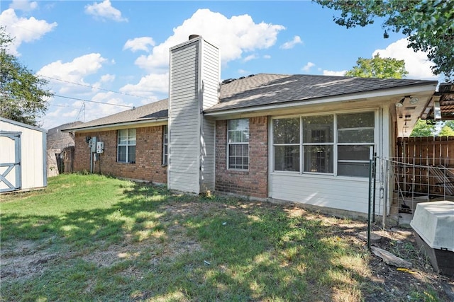 back of property with a shed and a lawn