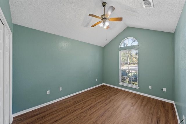 spare room with ceiling fan, wood-type flooring, a textured ceiling, and vaulted ceiling