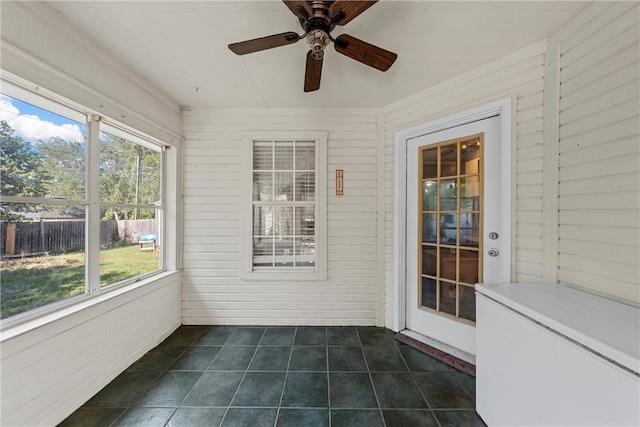 unfurnished sunroom with ceiling fan