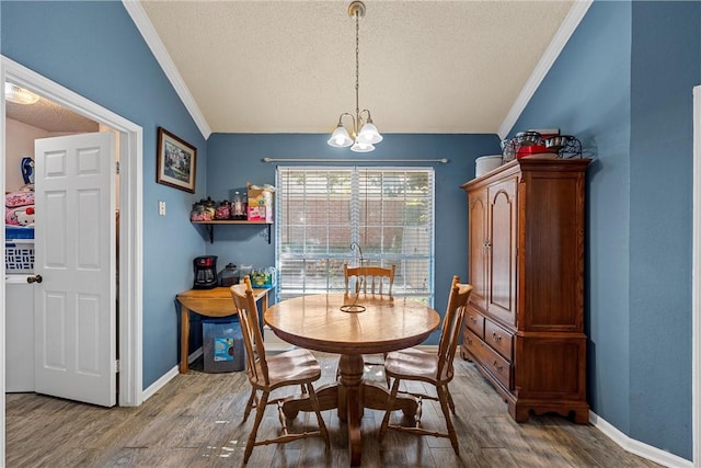 dining area with a textured ceiling, crown molding, vaulted ceiling, and hardwood / wood-style flooring