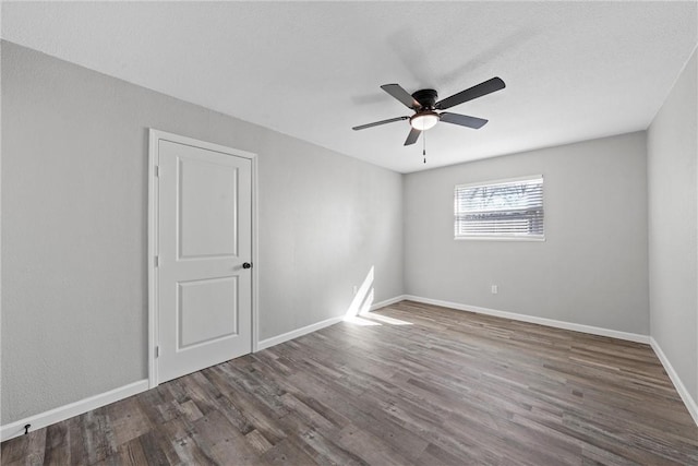 spare room featuring baseboards, a ceiling fan, and wood finished floors