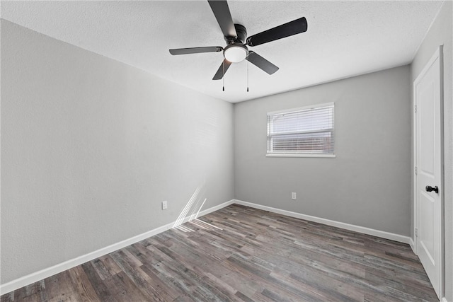 empty room featuring a textured ceiling, baseboards, and wood finished floors