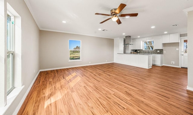 unfurnished living room with light hardwood / wood-style flooring, ceiling fan, and crown molding