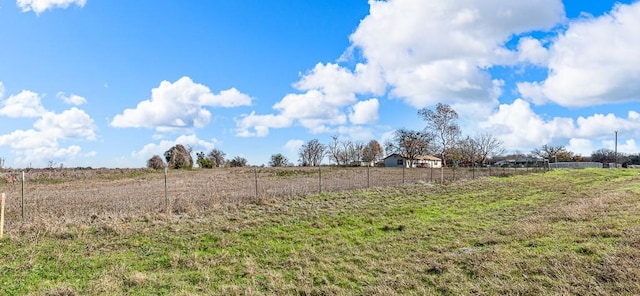 view of yard with a rural view and fence