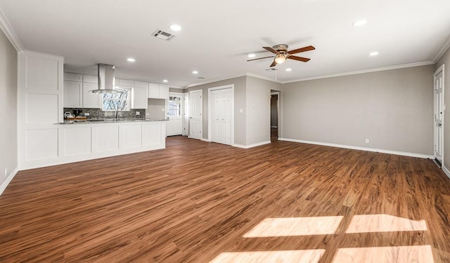 unfurnished living room featuring dark hardwood / wood-style floors, ceiling fan, and ornamental molding