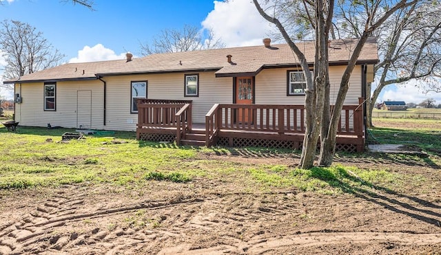 rear view of house with a yard and a wooden deck