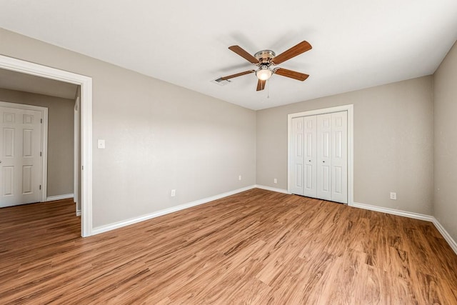 unfurnished bedroom featuring ceiling fan, a closet, and light hardwood / wood-style floors