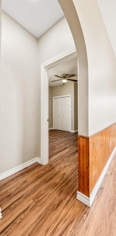 hall with wood walls and wood-type flooring