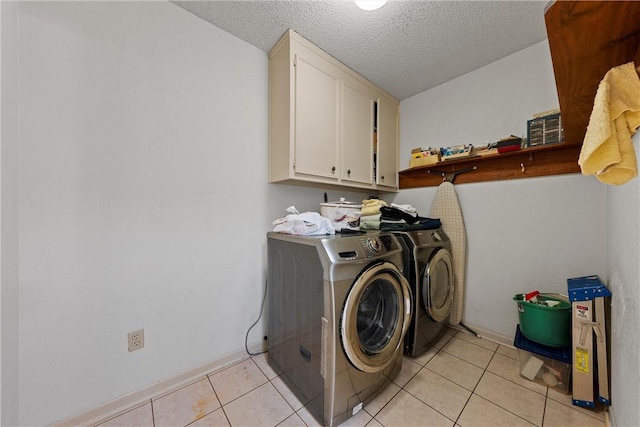 washroom with separate washer and dryer, light tile patterned floors, cabinets, and a textured ceiling