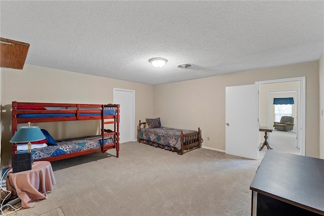 bedroom featuring light carpet and a textured ceiling