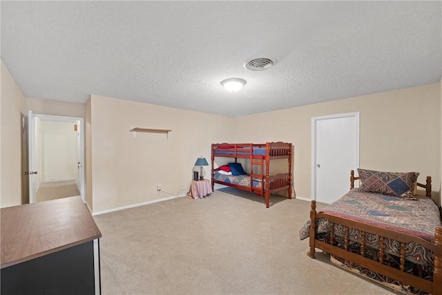 bedroom with light colored carpet and a textured ceiling