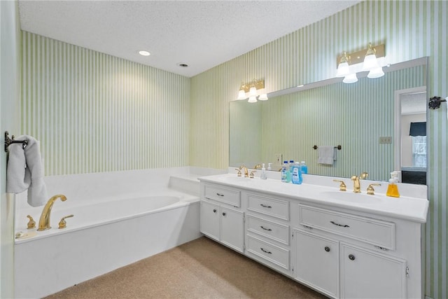 bathroom with vanity, a tub, and a textured ceiling