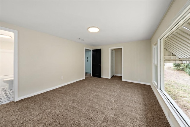 unfurnished bedroom with carpet, ensuite bathroom, and a closet