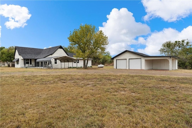 view of yard with a garage, a carport, and an outdoor structure