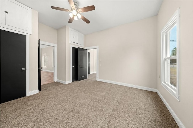 unfurnished bedroom with a closet, light colored carpet, and ceiling fan