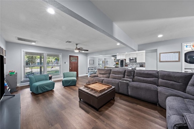 living room featuring recessed lighting, dark wood-style flooring, visible vents, and baseboards