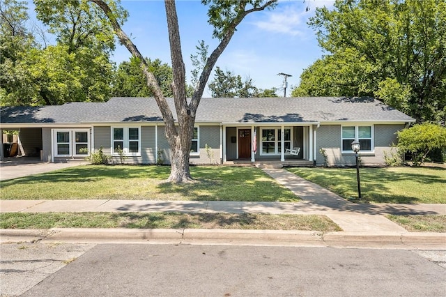 ranch-style home with covered porch, brick siding, a carport, and a front yard