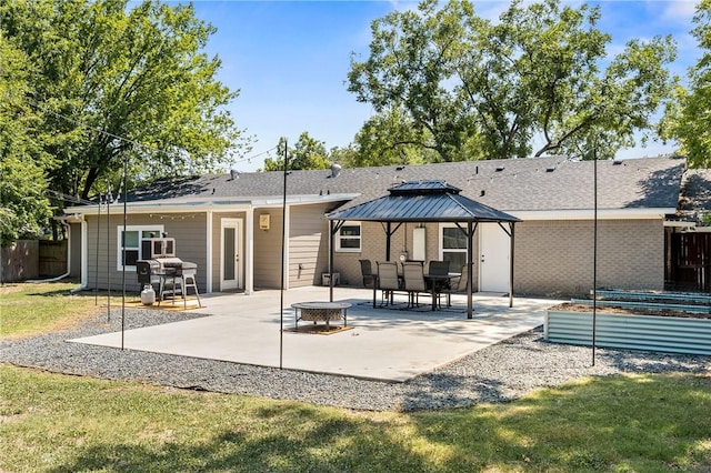 rear view of house with a fire pit, fence, a gazebo, a vegetable garden, and a patio area