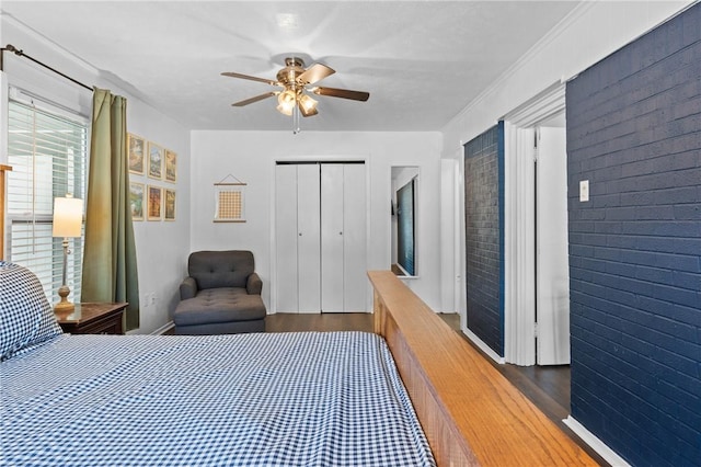 bedroom with brick wall, a closet, a ceiling fan, and wood finished floors