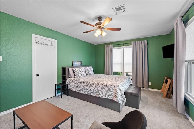 carpeted bedroom with ceiling fan, visible vents, and baseboards