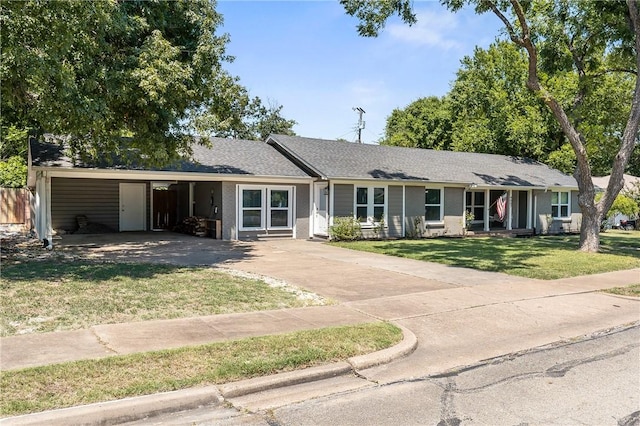 ranch-style house featuring entry steps, concrete driveway, a carport, and a front yard