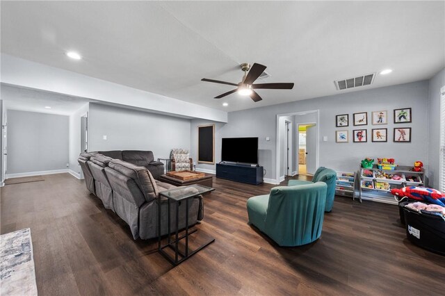 living room featuring baseboards, visible vents, and wood finished floors