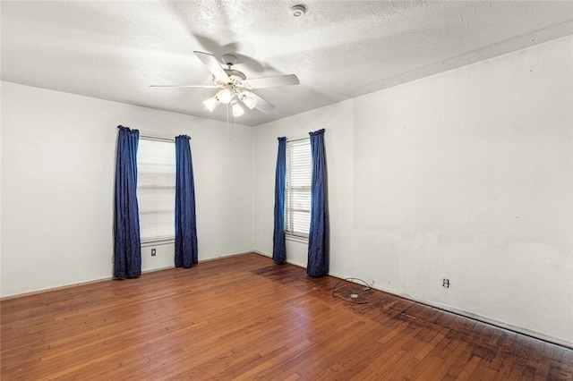 empty room with hardwood / wood-style floors, a textured ceiling, and ceiling fan