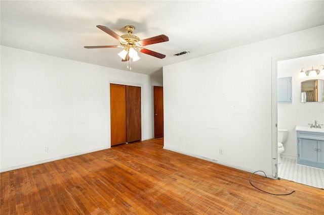 spare room with ceiling fan, light hardwood / wood-style flooring, and sink