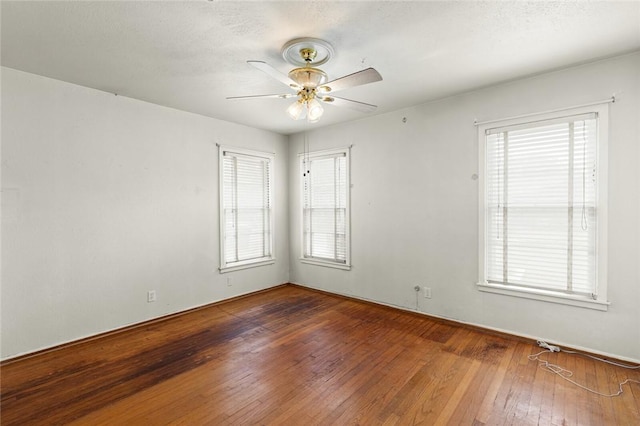 unfurnished room with dark hardwood / wood-style flooring, plenty of natural light, and ceiling fan